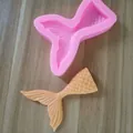 Detailansicht der rosa Meerjungfrauenschwanz-Silikonform mit fertigem orangefarbenem Fondant. - Kleiner Fischschwanz