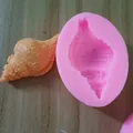 Detailed close-up of a pink seashell silicone mold with an orange fondant sample model. - 2#