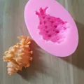 Detail showing a pink silicone sea shell mold with a finished orange conch shell - 4#