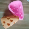 Detail of a triangular cheese-shaped silicone mold for DIY baking and chocolate cake decorating. - Medium