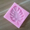 Macro view of a Monstera leaf shape inside a pink silicone mold for creative baking - Leaf