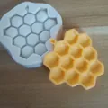 Detailed view of honeycomb silicone mold with a finished yellow craft on wooden background - Honeycomb Design / White