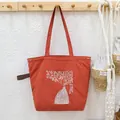 Large burnt orange drawstring tote bag with elegant white floral embroidery detail - Orange Branch