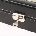 Detailopname van een zwarte PU-lederen horlogedoos met zilveren slot en sleutel. - All Black Interior / 24-Slot / Zwart