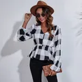 Detailed view of a black and white checkered V-neck chiffon blouse with lantern sleeves. - Black and White Large Plaid