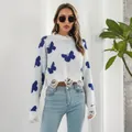 Detailed view of white Y2K distressed cropped sweater featuring blue butterfly patterns and rips - S / Tops / White