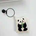 Close-up detail of a handmade canvas panda pendant keychain with a black bell and wire ring - Panda