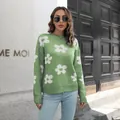 Detailopname van een casual groene gebreide trui met witte madeliefjes op een model - S / Tops / Lichtgroen