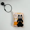 Primer plano de un adorable colgante de tela con diseño de conejo, aro de alambre y cascabel - Patrón de Conejo Doble