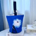 Artistic blue canvas bucket bag featuring a large white flower print and elegant pearl handle SKU - Blue Floral Portrait Print (04)