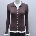 Close-up of a brown ribbed knit cardigan featuring white ruffles and golden buttons. - S / Tops / Brown