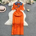 Vista detallada de un vestido polo de punto naranja con accesorios de verano sobre una alfombra. - S / Vestidos / Naranja