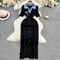 Detalle de un vestido de punto polo negro con cuello azul y bordado de la letra S. - S / Vestidos / Negro