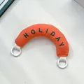Orange padded curved bag handle with green HOLIDAY embroidery and dual white ring clips - Handbag Style / Orange Handheld