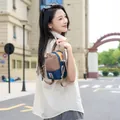 Detail of a lightweight outdoor sports crossbody bag worn by a model in an urban setting - Color Block Drawstring Style / Khaki-Royal Blue