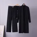 Detail shot of a black three-piece knitted cardigan set hanging on wooden hangers - One Size / Top And Bottom / Black