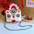 Detailed view of cute plush lion dance crossbody bag with embroidered festive patterns and strap - Pink Lucky Charm