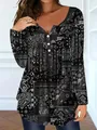 Detailed view of women's long sleeve tunic with black and white paisley print and buttons. - Black