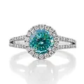 Macro view of a 1-carat cyan moissanite ring with halo setting and split shank design - US 5 / Cyan Round Multi-Faceted Cut (1ct) / Silver