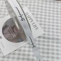 Elegant white grosgrain ribbon with black serendipity script for stylish gift wrapping - Serendipity / 1.5cm x 50 Yards / White