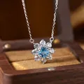 Detailed close-up of a flower pendant necklace featuring blue topaz and clear stones - Topaz (N537)
