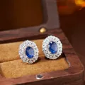 Detailed close-up of blue sapphire earrings in an elegant wooden jewelry box. - Natural Sapphire Earrings