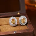 Detailed macro shot of oval yellow gemstone stud earrings in a wooden jewelry box. - Natural Citrine Stud Earrings