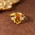 Detailed close-up showing the oval citrine gemstone and four-prong setting on a gold ring - Natural Citrine Gold