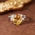 Close-up of elegant oval-cut citrine ring with silver setting and side stones - Natural Citrine Silver