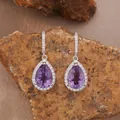 Detailed macro view of pear-shaped purple amethyst drop earrings with silver halo setting. - Natural Amethyst Stud Earrings