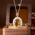 Macro view of a Millennium cut oval citrine pendant surrounded by halo stones. - Natural Citrine Necklace Silver