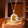 Close-up of large citrine pendant with sparkling pavé border in silver setting. - Necklace (Silver) / Yellow