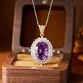 Macro shot of an elegant oval amethyst pendant necklace with shimmering halo stones in a gift box - Natural Amethyst Necklace