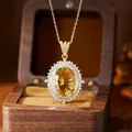 Detailed macro view of a large oval-cut yellow citrine pendant in a vintage wooden box - Natural Citrine Necklace