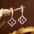 Macro detail of vintage silver earrings with red ruby clover design and sparkling crystals. - Natural Ruby Stud Earrings / 31.6x15.2mm