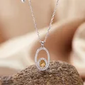 Close-up of S925 silver necklace with yellow gemstone in oval pendant on a rock - Necklace / Citrine