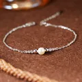 Nahaufnahme einer S925 Sterlingsilberkette mit einer zentralen Naturperle im Detail. - Natürliches Perlenarmband / Silber
