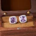 Close-up of cushion-cut amethyst earrings in a silver halo setting inside a wooden box - Natural Amethyst Stud Earrings