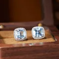 Elegant cushion-cut sky blue topaz stud earrings with a sparkling halo in a wooden jewelry box. - Natural Topaz Earrings