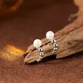 Detailaufnahme von S925 Sterling Silber Ohrsteckern mit Naturperlen auf einem Holzständer. - Naturperlenstecker / Silber