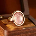 Detailed macro view of a rose gold bezel-set ring with an oval pink cabochon stone - Rose Quartz (R611) / Natural Rose Quartz Ring