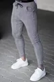 Detailed view of grey plaid slim-fit trousers with drawstring waist for men. - S / Bottoms / Gray
