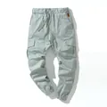 Detail view of men's cotton cargo joggers featuring multiple pockets and drawstring waist - M / Bottoms / Gray