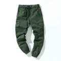 Detailed close-up of dark green cotton cargo pants featuring a drawstring waist and pockets - M / Bottoms / Green