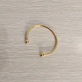 Detailed view of a gold titanium steel open cuff bracelet with screwable ball ends - Unscrewed Ball Head DIY Open Bangle (YB-219G) / Inner Diameter 60mm / Gold
