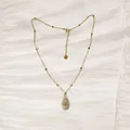 Primer plano del collar de acero inoxidable dorado con colgante de caracola natural - Estilo Caracol Gris Dorado (YN-1053-D)