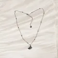 Detailed view of a silver stainless steel shell pendant necklace on elegant pleated silk - Silver Scallop Style (YN-1053-H-S)