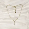 Detail view of a summer ocean themed stainless steel necklace with a white conch pendant - Gold Cowrie Shell Style (YN-1053-A)