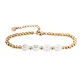Makroaufnahme eines vergoldeten Perlenarmbandes aus Edelstahl mit weißen CUTE-Muschelbuchstaben - CUTE Buchstaben Stil / Gold
