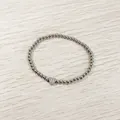 Close-up of a silver stainless steel beaded elastic bracelet with letter H heart charm. - Heart Initial H Style (YB-S1090-H) / Stretchy